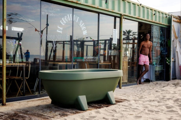 Olive Green Gardentub outdoor bathtub beside a beach pavilion