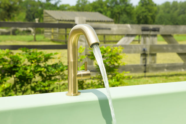 Gouden kraan vult een Lime Green Gardentub met water.